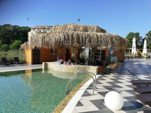 a resort with a swimming pool and a straw hut at Donchevi Apartments in Primorsko
