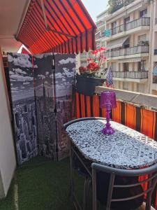 d'une table et de chaises sur un balcon avec un parasol dans l'établissement CHAMBRE CHEZ L'HABITANT - ROOM IN THE OWNER'S APARTMENT, à Nice