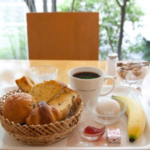 ein Tablett mit einem Korb Brot und einer Tasse Kaffee in der Unterkunft 7 Days Hotel in Kōchi