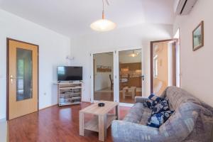 a living room with a couch and a table at Apartments Kadum 25 in Poreč