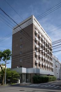 高知市にあるセブンデイズホテルプラスの通り側の大きなレンガ造りの建物