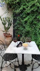 a table with two glasses of wine and two chairs at B&B del Giglio in Cefalù