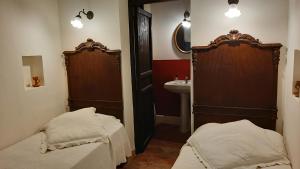 a small bathroom with two beds and a sink at B&B del Giglio in Cefalù