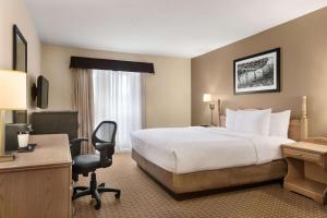 a hotel room with a bed and a desk at Travelodge Suites by Wyndham Moncton in Moncton