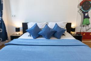 ein blau-weißes Bett mit blauen Kissen darauf in der Unterkunft Yeshello Apartment near Central Station in Wien