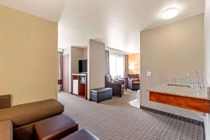 um quarto de hotel com uma sala de estar com um sofá e uma sala de estar em Comfort Suites Burlington em Burlington