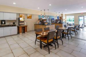 Comfort Suites Burlington في برلينغتون: مطبخ وغرفة طعام مع طاولات وكراسي