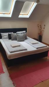 ein großes Bett mit zwei Kissen darauf in einem Zimmer in der Unterkunft PENSIUNE RESTAURANT OVIDIU in Valea lui Mihai