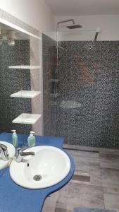 a bathroom with a white sink and a shower at PENSIUNE RESTAURANT OVIDIU in Valea lui Mihai