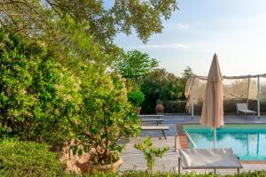 - Piscina con sombrilla, mesa y sillas en La Casa Medioevale, en Lamporecchio