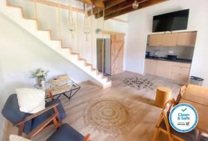 a living room with a staircase and a table and chairs at Sete Cidades Nature Villa in Sete Cidades
