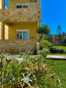 a house with a garden in front of it at Ermis Suites in Platanias