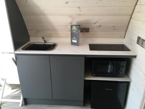 eine kleine Küche mit einer Spüle und einer Mikrowelle in der Unterkunft Low Greenlands Holiday Park - Luxury House & Luxury Glamping Pods in Lancaster