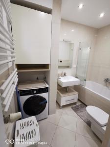 a white bathroom with a sink and a stove at Kameralna Głębocka in Warsaw
