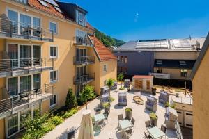 un patio de apartamentos con sillas, mesas y edificios en STEIGER Apparthotel Bad Schandau, en Bad Schandau