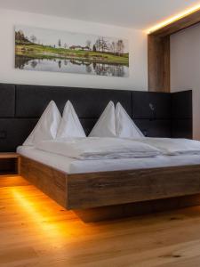 a bed with white pillows on it in a room at Mitten in der Welt - GH Roither in Herzogsdorf