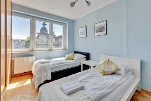 Duas camas num quarto com uma janela em Grand Apartments - Apartment for 7 people in Sopot em Sopot