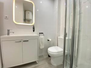 uma casa de banho com um WC, um lavatório e um espelho. em Project Montalvão em Setúbal