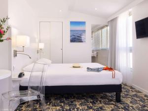 a hotel room with a bed and a view of the ocean at Ibis Styles Menton Centre in Menton