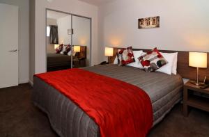 - une chambre avec un grand lit et une couverture rouge dans l'établissement Lincoln Motel, à Lincoln