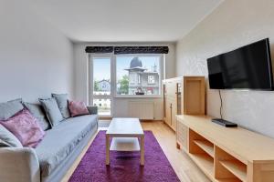 uma sala de estar com um sofá e uma televisão de ecrã plano em Grand Apartments - Apartment for 7 people in Sopot em Sopot