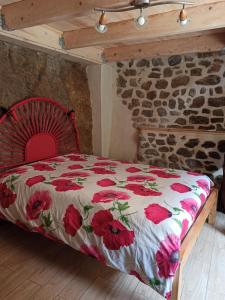 a bedroom with a bed with a floral comforter at Gîte les coquelicots de Retourtour in Lamastre