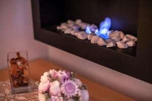 a table with a cake and a fire in a fireplace at Apartmán Skalka 11 in Donovaly