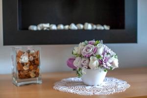 um vaso cheio de flores sentado numa mesa em Apartmán Skalka 11 em Donovaly