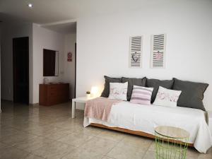 1 dormitorio con 1 cama grande con almohadas rosas y grises en IT HOME - 2 Private Apartments, en Telde