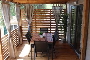 eine Terrasse mit einem Tisch und Stühlen auf einer Terrasse in der Unterkunft Two Sisters mobile home in Biograd na Moru