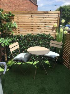 a table and two chairs in a yard with a fence at OurHaus in Beverley