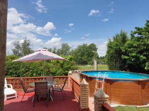 een patio met een tafel, een parasol en een zwembad bij Villa CiTe- jardines/BBQ/terrazas/ para familias in Teruel