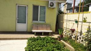 a bench sitting in front of a house at Гостевой домик in Chornomorsk