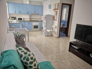 een woonkamer met een bank en een keuken bij IT HOME - 2 Private Apartments in Telde