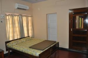 a bedroom with a bed and a window and a door at Nandanam Homestay in Trivandrum