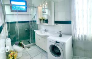 een badkamer met een wasmachine en een wastafel bij Villa Katerina in Stalida