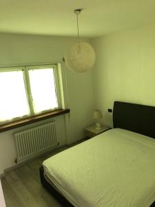 Tenna にあるValsugana d'incantoのベッドルーム1室(ベッド1台、窓2つ付)