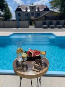 een dienblad met eten en drinken op een tafel naast een zwembad bij BOHO HOUSE in Ustrzyki Dolne