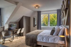 1 dormitorio con 1 cama, mesa y sillas en B & B De Elsterberg en Elst