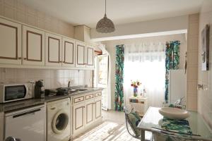 a kitchen with white cabinets and a sink and a microwave at Cantinho D'Os Reais in Pinhão