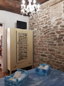 um quarto com uma parede de pedra, uma cama e um lustre em Non ditelo al Duca - La Cappuccina em Spoleto