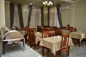 een restaurant met tafels en stoelen en een kroonluchter bij Hancol Hotel in Dodoma