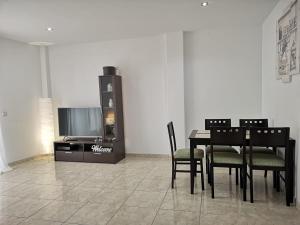 comedor con mesa, sillas y TV en IT HOME - 2 Private Apartments, en Telde