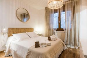 sypialnia z łóżkiem z białą pościelą i lustrem w obiekcie APARTAMENTO MOIRA en Bielsa w mieście Bielsa