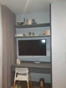 a computer desk with a monitor and a white chair at Woodstock Studio Apartments in Cape Town