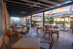 an empty restaurant with tables and chairs and umbrellas at Albatros Family in Salou