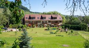 uma casa grande num campo verde com um quintal em Résidence Froehn em Andlau