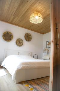 a bedroom with a white bed and a wooden ceiling at Sete Cidades Nature Villa in Sete Cidades