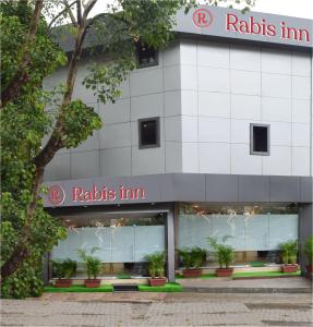 a building with a raiths firm sign on it at Hotel Rabis Inn in Mumbai