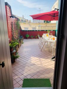 a patio with a table and a red umbrella at Starnone Bed&Book in Naples